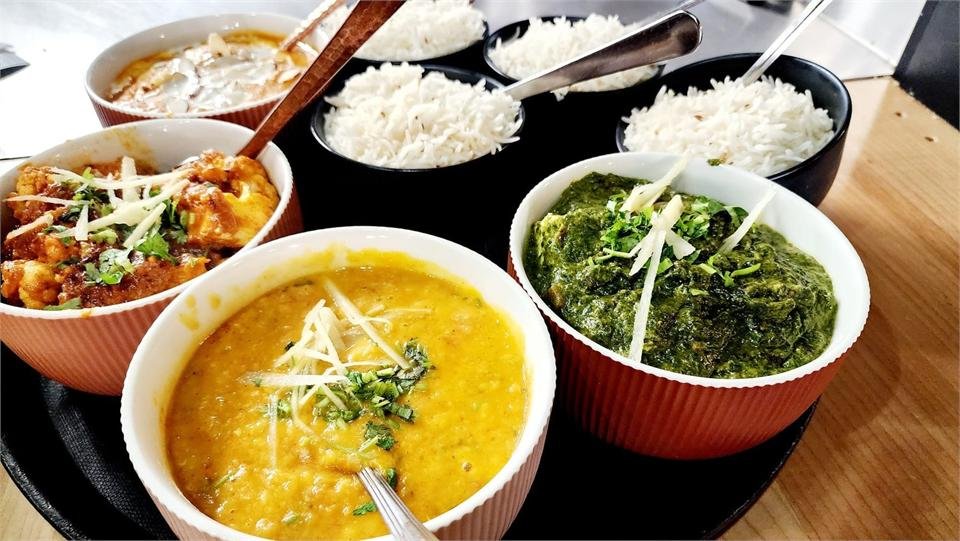 A tray of vegetarian curries, rice and naan